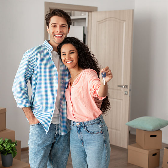 Happy couple posing with keys on moving day