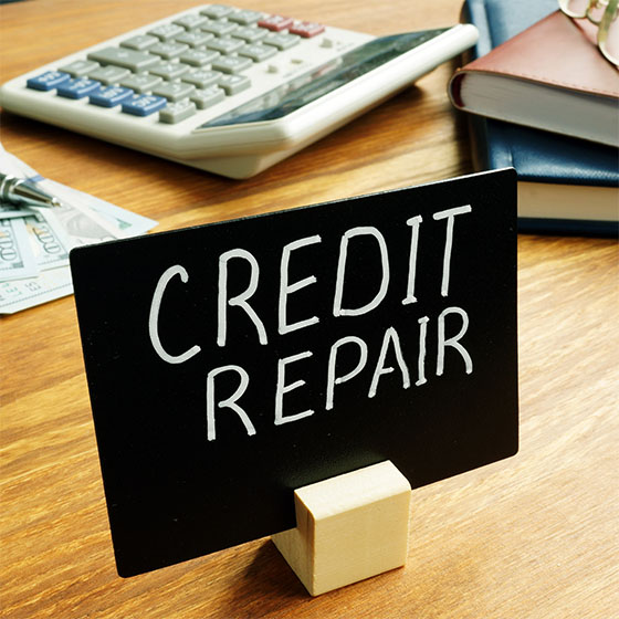 Credit repair sign and calculator on a desk