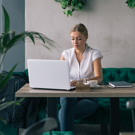 Woman working on laptop in cafe bar