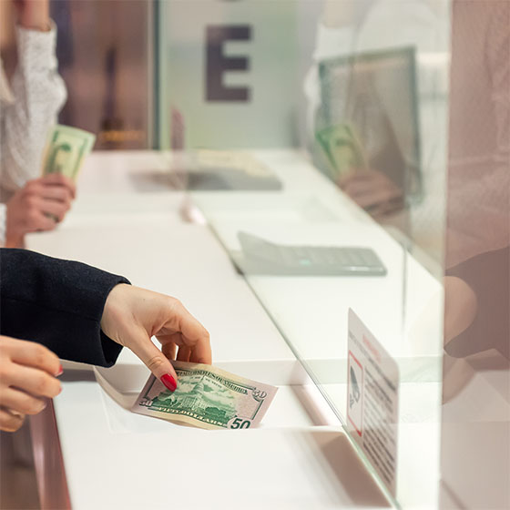 Female hand with money at a teller widow